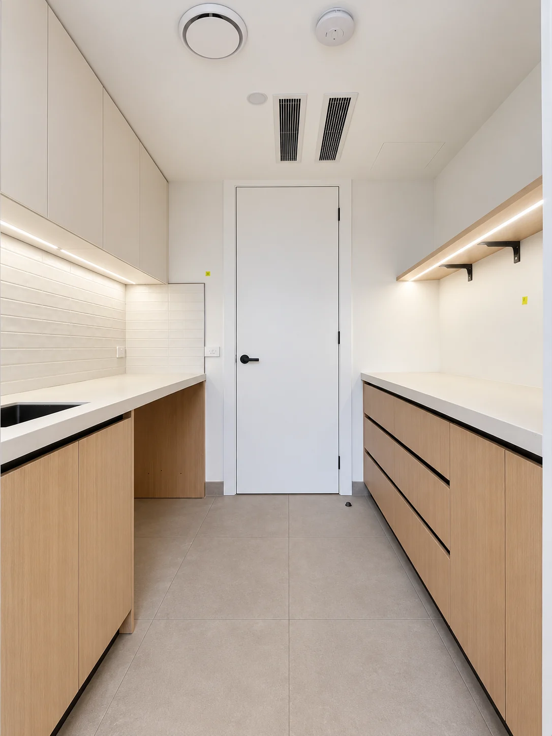 Conrad Residence pantry with timber cabinetry, grey drawers and stone worktops.