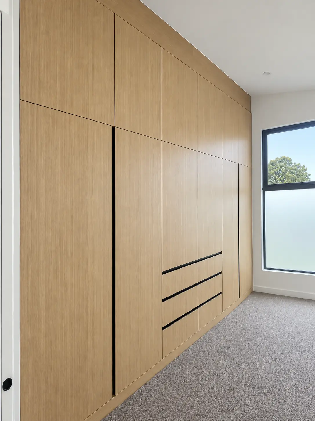 Full-height timber wardrobe with integrated drawers at the Conrad Residence.