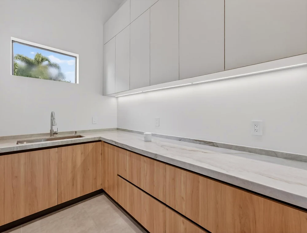 Additional cabinetry with wood-finish base units and pale wall units in the Miami project