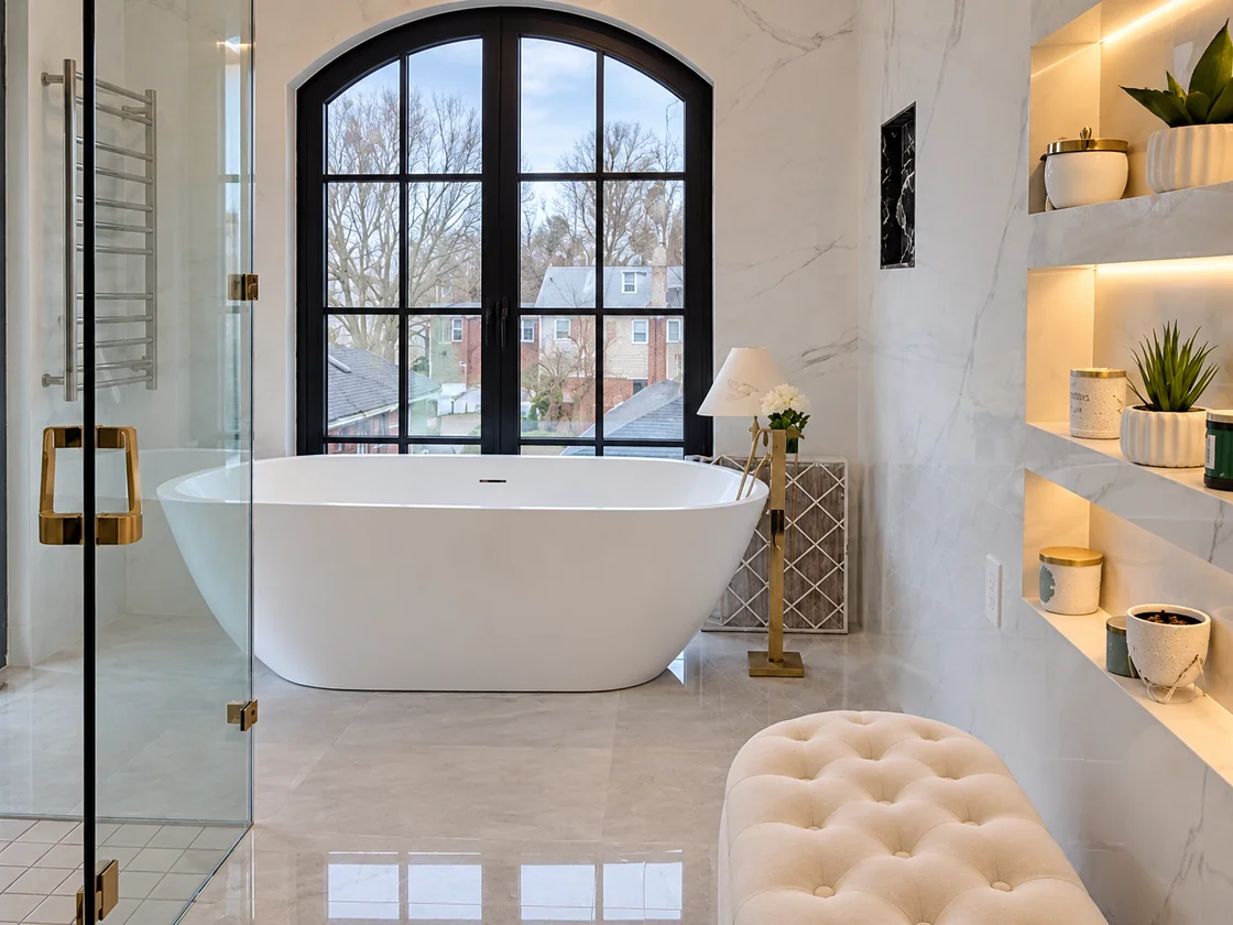 Freestanding white bathtub below an arched window in the villa bathroom