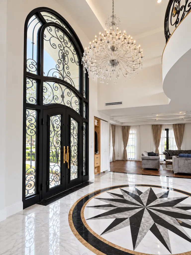 Marble foyer with a radial floor medallion and tall arched entrance door in the New Jersey villa